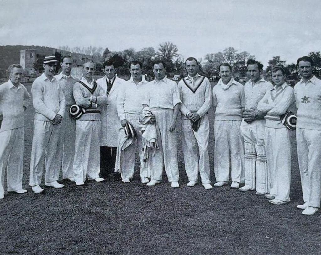 Black and white photo of an early LNZCC side lined up in whites on the outfield